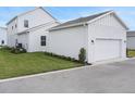 View of the side of the house showing a two car garage and some landscaping at 9035 Duany Ln, Lakewood Ranch, FL 34240