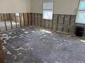 A spacious living room featuring exposed concrete block walls and partially removed flooring at 9015 Bay Ne St, St Petersburg, FL 33702