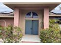 Inviting front entrance with double doors, arched transom window, and colorful landscaping at 3604 Bula Ln, North Port, FL 34287