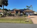 Inviting single-story home with solar panels, long drive, mature plants and a decorative front yard at 3604 Bula Ln, North Port, FL 34287