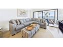 Comfortable living room featuring a plush sectional sofa, stylish decor, and sliding glass doors to the lanai at 6365 Bahia Del Mar Blvd # 210, St Petersburg, FL 33715