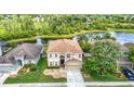 Stunning aerial view of home with lake access and mature landscaping in a beautiful community at 18441 New London Ave, Land O Lakes, FL 34638