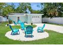 Backyard includes garage, fire pit, & several turquoise adirondack chairs, creating a great outdoor space at 418 40Th S Ave, St Petersburg, FL 33705