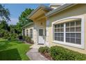 Inviting front entrance with decorative door, sidelight windows, and manicured landscaping at 1188 Royal Blvd, Palm Harbor, FL 34684