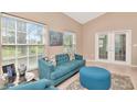 Bright living room features tile floors, large windows, and comfortable blue furniture at 1188 Royal Blvd, Palm Harbor, FL 34684