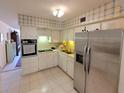 Bright kitchen featuring stainless steel appliances, white cabinetry, and tile flooring at 2311 Brisbane St # 29, Clearwater, FL 33763