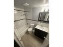 Cozy bathroom featuring tiled walls, a shower and tub combo, and a modern vanity at 6019 W Fern St, Tampa, FL 33634