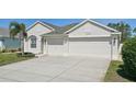Charming home featuring a three car garage, well manicured lawn, and an inviting front entrance at 6335 Cardinal Crest Dr, New Port Richey, FL 34655