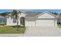 Charming home featuring a three car garage, well manicured lawn, and an inviting front entrance at 6335 Cardinal Crest Dr, New Port Richey, FL 34655