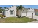 Charming home featuring a three car garage, well manicured lawn, and an inviting front entrance at 6335 Cardinal Crest Dr, New Port Richey, FL 34655
