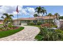 Inviting home with a brick driveway, landscaped yard, and mature palms offering curb appeal at 1120 81St S St, St Petersburg, FL 33707