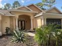 Inviting single-story home with a welcoming entryway and an attached multi-car garage at 7190 Raymond Pl, Spring Hill, FL 34607