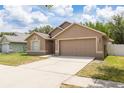Exterior shot of a single-story home with a two-car garage and well-manicured front lawn at 18941 Twinberry Dr, Tampa, FL 33647