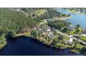 Scenic aerial view featuring a lakeside property with tree coverage and neighboring homes creating a peaceful community at 18101 Boy Scout Rd, Odessa, FL 33556