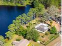 Aerial view showcases a lakeside property with a lush green lawn and mature trees creating a serene backyard at 18101 Boy Scout Rd, Odessa, FL 33556