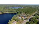 Breathtaking aerial view of a lakeside home surrounded by tall pines and lush greenery offers ultimate privacy at 18101 Boy Scout Rd, Odessa, FL 33556
