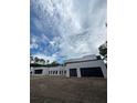 A modern-style home featuring black garage doors, white exterior, and contemporary architectural design at 2518 Sunset Ln, Lutz, FL 33559