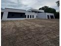 Contemporary home with a minimalist design, black accents, and a large yard needing landscaping at 2518 Sunset Ln, Lutz, FL 33559
