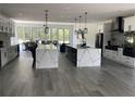 A large kitchen showcasing double islands with Quartz countertops, modern pendant lights, and open floorplan at 2518 Sunset Ln, Lutz, FL 33559
