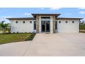 Charming single-story home with a stylish front entrance and a spacious driveway surrounded by manicured landscaping at 5479 S Biscayne Dr, North Port, FL 34287