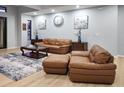 Comfortable living room with leather furniture, a patterned rug, and neutral wall colors at 5479 S Biscayne Dr, North Port, FL 34287