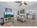 Inviting living room with grey floors, light blue walls, and modern ceiling fan at 4444 5Th S Ave, St Petersburg, FL 33711