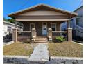 Charming single-story home featuring a covered front porch with brick supports and inviting curb appeal at 917 E 15Th Ave, Tampa, FL 33605