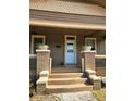 Inviting front porch with brick supports, decorative planters, and a freshly painted white front door at 917 E 15Th Ave, Tampa, FL 33605