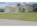 Inviting single-story home with an attached two-car garage and a well-manicured lawn, perfect for families at 4611 Herman Cir, Port Charlotte, FL 33948