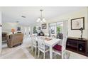 Bright dining area with a modern chandelier and sliding glass doors to the patio, perfect for entertaining at 6948 W Country Club N Dr, Sarasota, FL 34243