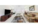 Inviting living room features neutral walls, plush carpeting, and a cozy seating area with natural light at 6948 W Country Club N Dr, Sarasota, FL 34243