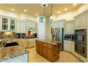 Gourmet kitchen featuring granite countertops, custom cabinets, stainless steel appliances, and a center island at 14041 Bassingthorpe Dr, Spring Hill, FL 34609