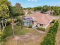 Aerial view of home with screened-in pool, landscaping, and backyard at 1052 Archway Dr, Spring Hill, FL 34608