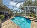 Beautiful screened pool area with brick pavers and well-maintained landscaping at 1052 Archway Dr, Spring Hill, FL 34608