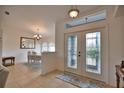 Welcoming foyer with decorative glass double doors and tile flooring, leading to a dining area with a chandelier at 536 Boundary Blvd, Rotonda West, FL 33947