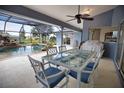 Covered patio features a glass table with cushioned chairs, offering a perfect spot for outdoor dining overlooking the pool at 536 Boundary Blvd, Rotonda West, FL 33947