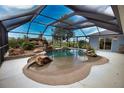 Inviting screened-in pool area featuring a rock waterfall, spa, and ample lounging space, creating a backyard oasis at 536 Boundary Blvd, Rotonda West, FL 33947