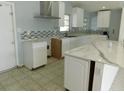 Bright kitchen with white cabinets, stylish backsplash, stone countertops, and ample counter space at 21970 Cellini Ave, Port Charlotte, FL 33952