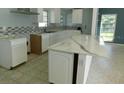 Bright kitchen with white cabinets, stylish backsplash, stone countertops, and ample counter space at 21970 Cellini Ave, Port Charlotte, FL 33952
