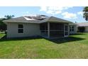 Spacious backyard featuring a screened lanai, lush lawn, and mature trees surrounding the property at 401 Malpelo Ave, Punta Gorda, FL 33983