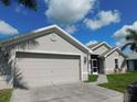 Well-maintained single-story home with lush lawn, mature trees, and a driveway leading to an attached two-car garage at 401 Malpelo Ave, Punta Gorda, FL 33983