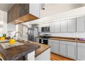 Modern kitchen features updated cabinets, stainless steel appliances, wood countertops, and stylish backsplash at 23338 Duchess Ave, Port Charlotte, FL 33954