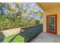 Private patio with orange door and view of wooded area at 3923 Mediterranea Cir # 211, Sarasota, FL 34233