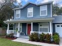 Two-story house with blue siding, red door, and a white porch at 6704 N 13Th St, Tampa, FL 33604