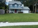 Two-story house with blue siding, red door, and a well-maintained lawn at 6704 N 13Th St, Tampa, FL 33604