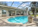 Inviting pool area with covered patio, lounge seating, and a fire pit at 2553 Regal River Rd, Valrico, FL 33596