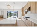 Modern kitchen with light wood cabinets and a large island at 116 Wimbledon Ct, Redington Shores, FL 33708
