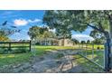 Long driveway leading to a charming ranch home with a gated entrance at 8016 Carey Rd, Lithia, FL 33547