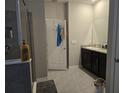 Bathroom with shower, double vanity, and dark brown cabinets at 16988 Oval Rum Dr, Wimauma, FL 33598