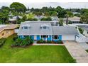 Aerial view of a charming blue home, garage, well-kept lawn and landscaped yard at 5260 42Nd S St, St Petersburg, FL 33711